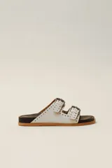 Sandalias marrones de cuero vacuno con doble tira y hebillas metálicas ajustables.