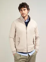 Cazadora tipo bomber color beige, con cierre frontal y bolsillos de solapa.