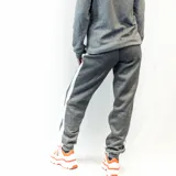 Pantalón de jogging gris con interior afelpado y raya blanca a los costados.