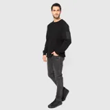 Sweater negro de punto con cuello redondo y manga larga. Presenta un bolsillo con cierre en la manga izquierda.