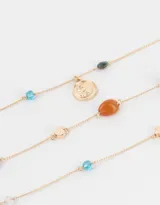 Set de tres collares cortos dorados con cuentas de colores y dijes metálicos.