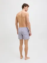 Short de baño lila con cintura elástica ajustable con cordón. Estampado lateral con el logo de la marca y texto en blanco.
