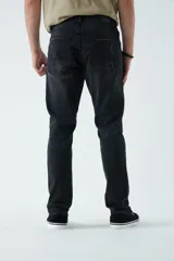 Pantalón de jean negro con roturas, corte recto y tiro medio.