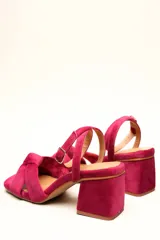 Sandalia de terciopelo verde con taco cuadrado de 7 cm, punta cuadrada y tiras anchas anudadas en el empeine. Cuenta con una tira fina ajustable al tobillo con hebilla dorada.