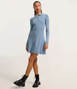 Vestido corto negro de punto con cuello polo, manga larga y botones en el escote.
