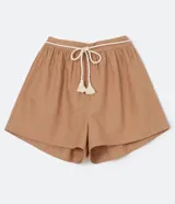 Short ancho color marrón claro, confeccionado en algodón, viscosa, modal y lino. Presenta pliegues y cordón trenzado en la cintura.
