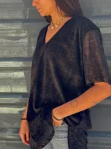 Remera negra con brillo dorado, de mangas cortas y escote en V.