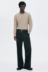 Buzo de punto fino color beige, con cuello redondo y manga larga, corte regular fit.