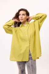 Camisa oversize a rayas verticales color amarillo y blanco, con cuello camisero, manga larga y cierre frontal con botones.