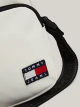 Bandolera blanca con correa ancha negra con logo Tommy Jeans. Tiene el logo de la marca en la parte inferior.