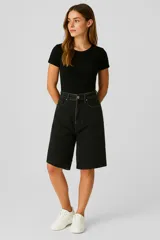 Bermuda de jean negro lavado, tiro alto, corte recto y ancho que llega hasta la rodilla.