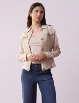Campera color beige de algodón con cuello camisero, abertura central con botones de madera, bolsillos de parche en el pecho y mangas largas con puños abotonados.