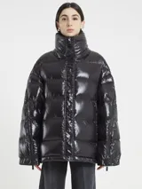 Campera puffer negra de acabado brillante, con cuello alto y cierre frontal. Presenta cierres funcionales en las mangas.