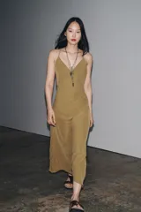 Vestido largo marrón de Zara Woman Collection, confeccionado en viscosa y lyocell. Presenta escote en pico y tirantes finos cruzados en la espalda.