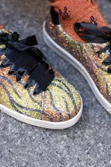 Zapatillas deportivas con estampado de tigre, cordones de raso negros y detalles en ante negro en el talón.