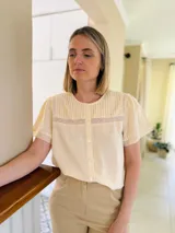 Camisa color amarillo manteca de lino, con cuello a la base, tablitas en el frente y puntilla.