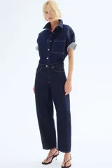 Pantalón de jean azul oscuro de corte holgado, con tiro alto, cinco bolsillos y cierre con botón.