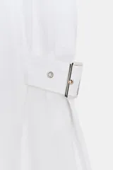 Vestido midi negro de lino, sin mangas, con cuello solapa, escote pico, botones frontales y trabillas con hebillas en la cintura.