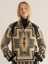 Abrigo jacquard con diseño gráfico en tonos beige y negro, abotonado y de corte largo.