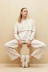 Canguro marrón con capucha, corte amplio y detalle de recorte frontal.