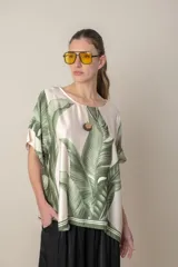 Blusa italiana color natural con estampado de hojas en tonos azules. De calce holgado y talle único.