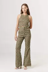 Top corto tipo crop top, sin mangas y con cuello halter. Presenta un estampado grande de flores en tonos verde claro, verde azulado y beige/crema.