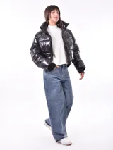 Campera puffer corta color negro brillante, con cuello alto, cierre frontal y puños ajustados.