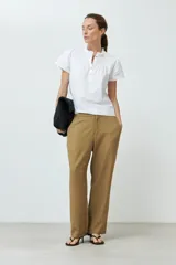 Blusa blanca con punto smock en el cuello, manga corta y cierre con botones.