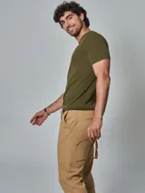 Pantalón color beige con cintura elastizada y cordón ajustable. Corte recto y bolsillos laterales.