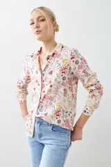 Camisa de manga larga con cuello clásico y estampado floral multicolor sobre fondo blanco.
