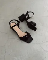 Sandalia plateada de cuero vacuno con taco cuadrado de 6 cm y tira delantera con nudo.