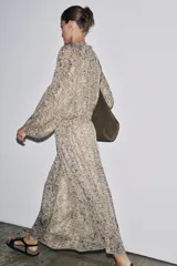 Vestido largo con estampado floral multicolor, cuello redondo con lazo ajustable, mangas largas abullonadas con puños elásticos y forro interior.