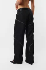 Pantalón negro de corte recto y tiro medio, con recortes en las piernas con detalle de vivo. Cintura con presillas y cinto correa con broche plástico incluido.