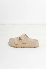 Sandalias color rosa con doble hebilla ajustable y suela marrón.