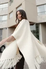 Ruana tejida en lana merino color amarillo pastel, con terminación de flecos.