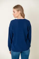Cardigan celeste de lana con escote en V y botones marrones.