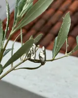 Anillo de diseño orgánico y macizo, realizado artesanalmente en bronce. Presenta una estructura abierta con dos piezas de forma irregular y textura rugosa.