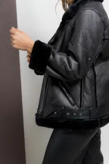 Gamulan negro de ecocuero con interior de símil piel, cuello solapa y cierre lateral con cremallera.