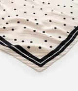 Pañuelo cuadrado de poliéster color crema con estampado de lunares negros y borde con doble línea negra.