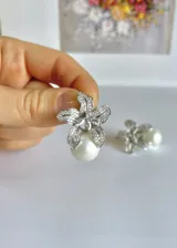 Aros colgantes con forma de flor, hechos en plata 925 con circonitas y perlas blancas.