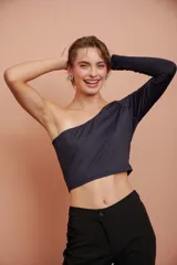 Top corto negro de un hombro con manga larga ajustada.