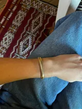 Pulsera dorada con eslabones tipo espiga y cierre de mosquetón.