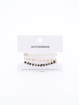 Set de tres pulseras doradas, una de eslabones grandes, otra de eslabones pequeños y una con piedras negras irregulares.