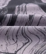 Vestido midi de tul con estampado efecto mármol en tonos lila y gris. Tiene mangas largas, cuello redondo y terminaciones onduladas.