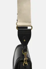 Bolso bandolera color marrón con solapa y correa ancha de tela color crudo.