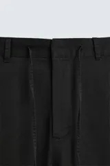 Pantalón negro de corte recto y calce relajado, confeccionado en tejido de algodón con elasticidad. Presenta cintura ajustable con cordón, bolsillos frontales y bolsillos traseros de doble vivo.