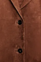 Blazer de cuero color marrón, con cuello solapa de muescas y manga larga. Tiene bolsillos con solapa en delantero, forro interior y cierre frontal con botones.