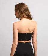 Blusa cropped con escote strapless, confeccionada en tul metalizado con brillos aplicados y cierre track.