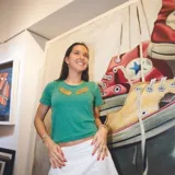 Remera verde de algodón de manga corta con aplique de alas doradas en el pecho.