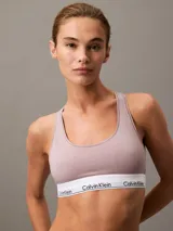 Conjunto de ropa interior Calvin Klein color lila, compuesto por un corpiño deportivo sin aro ni relleno, con espalda cruzada y banda elástica con logo, y una bombacha tipo tanga con cintura elástica con logo.